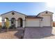 Tan two-story house with a three-car garage and desert landscaping at 5203 W Roundhouse Rd, Laveen, AZ 85339