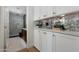 Laundry room with white cabinets and a mirrored backsplash at 8701 E Highland Ave, Scottsdale, AZ 85251
