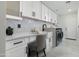 Bright laundry room with white cabinets, farmhouse sink, and modern washer and dryer at 8701 E Highland Ave, Scottsdale, AZ 85251