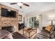 Spacious living room with a stone fireplace and patio access at 9450 E Becker Ln # 1094, Scottsdale, AZ 85260