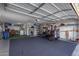 Garage with golf cart, storage shelves, and epoxy floor at 9913 W Pleasant Valley Rd, Sun City, AZ 85351