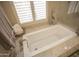 Relaxing bathroom with soaking tub, neutral tile, and window at 26702 N 97Th Ln, Peoria, AZ 85383