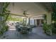 Covered patio with dining area and ceiling fan, overlooking a lush backyard at 26702 N 97Th Ln, Peoria, AZ 85383