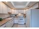 Clean and efficient kitchen featuring white cabinets, updated appliances, and tile floors at 7820 E Camelback Rd # 209, Scottsdale, AZ 85251