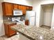 Kitchen with granite countertops and wood cabinets at 1445 E Broadway Rd # 120, Tempe, AZ 85282