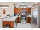 Well-equipped kitchen with stainless steel appliances and wood cabinets at 19760 N Hidden Ridge Dr, Surprise, AZ 85374