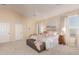 Main bedroom with high ceilings, plush bedding, and ensuite bathroom access at 25714 N 70Th Ln, Peoria, AZ 85383