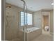 Elegant bathroom with a soaking tub, glass shower, and gold fixtures at 2626 E Arizona Biltmore Cir # 40, Phoenix, AZ 85016