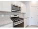 Stainless steel gas range and microwave in a modern kitchen setting at 39995 W Bravo Dr, Maricopa, AZ 85138