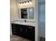 Modern bathroom with dark vanity, granite countertop, and gold accents at 4237 E 4Th Ave, Apache Junction, AZ 85119