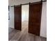 Bedroom with barn door entry and wood-look flooring at 4237 E 4Th Ave, Apache Junction, AZ 85119