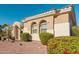 Tan stucco house with arched entryway, landscaping, and a two-car garage at 12844 W El Sueno Dr, Sun City West, AZ 85375