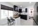 Modern kitchen with dark cabinetry, island, and stainless steel appliances at 2143 W Wilshire Dr, Phoenix, AZ 85009