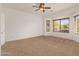 Carpeted bedroom with ceiling fan and large window at 3671 N Monument Dr, Florence, AZ 85132