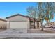 Single-story house with a beige exterior, two-car garage, and a well-manicured front yard at 9273 W Sheridan St, Phoenix, AZ 85037