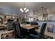 Open dining area with a large table, black chairs, and a view into the living room and kitchen at 16316 W Willow Creek Ln, Surprise, AZ 85374