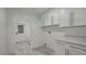 Bright laundry room with white cabinets and built-in bench at 2809 E Frye Rd, Phoenix, AZ 85048