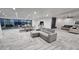 Spacious living room with gray sectional sofa and dining area, featuring large windows and wood-look tile floors at 2809 E Frye Rd, Phoenix, AZ 85048
