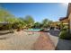 Relaxing backyard with a sparkling pool, covered patio, and mature desert plants at 12721 S 177Th Ave, Goodyear, AZ 85338