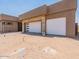 Two-car garage with modern white doors and stone accents at 37200 N Cave Creek Rd # 1023, Scottsdale, AZ 85262