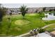 Aerial view of a golf course with a pond and players at 520 S Greenfield Rd # 21, Mesa, AZ 85206