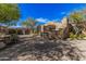 Luxury home exterior showcasing stonework, arched entryway, and a spacious driveway at 7552 E Whisper Rock Trl, Scottsdale, AZ 85266