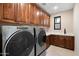 Laundry room with Whirlpool washer and dryer and ample cabinetry at 14174 E Highland Ave, Fountain Hills, AZ 85268