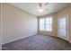 Spacious bedroom with ceiling fan, window, and carpet flooring at 14950 W Mountain View Blvd # 1310, Surprise, AZ 85374