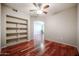 Bedroom with hardwood floors, built-in shelving, and ceiling fan at 14950 W Mountain View Blvd # 1310, Surprise, AZ 85374
