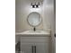 Bathroom features a vanity with round mirror and modern lighting at 15200 S Capistrano Rd, Arizona City, AZ 85123