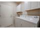 Laundry room with washer, dryer, and ample cabinets at 15805 W Arrowhead Dr, Surprise, AZ 85374