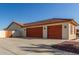 Three-car garage with orange doors and a concrete driveway at 30124 W Mckinley St, Buckeye, AZ 85396