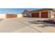 Three-car garage with orange doors and a concrete driveway at 30124 W Mckinley St, Buckeye, AZ 85396