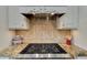 Kitchen stove with granite countertop, decorative backsplash, and white cabinetry at 3291 E Cherrywood Pl, Chandler, AZ 85249