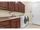 Laundry room with washer, dryer and wood cabinets at 3291 E Cherrywood Pl, Chandler, AZ 85249