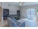 Bright living room with gray sofas, built-in shelving, and sliding glass door at 7439 W Tonopah Dr, Glendale, AZ 85308