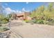 Desert landscape surrounds this stucco home with a long driveway at 9290 E Thompson Peak Pkwy # 430, Scottsdale, AZ 85255