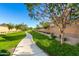 Paved path winds through a green space with lush landscaping and mature trees at 1023 W Ingram St, Mesa, AZ 85201