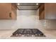 Gas cooktop with stainless steel range hood and white tile backsplash at 375 E Bracciano Ave, Queen Creek, AZ 85140
