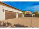 Three-car garage with attached casita and wrought-iron gate at 5791 S Columbus Ct, Gilbert, AZ 85298