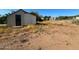 Backyard with shed, overgrown weeds, and distant neighborhood view at 709 N San Manuel Ave, Mammoth, AZ 85618