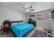 Bedroom with a teal comforter, ceiling fan, and large window at 1219 E Barcelona Ave, Casa Grande, AZ 85122