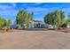 Front view of a single-story house with a large driveway and mature trees at 3401 N Dakota St, Chandler, AZ 85225