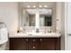 Double vanity bathroom with dark wood cabinets and mirrors at 4311 E Roma Ave, Phoenix, AZ 85018