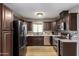 Modern kitchen with dark wood cabinets and stainless steel appliances at 4311 E Roma Ave, Phoenix, AZ 85018