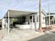 Mobile home with covered patio, stone patio, and palm tree at 523 S Jaspar Dr, Apache Junction, AZ 85119