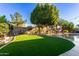 Spacious backyard with artificial turf and a large tree at 11957 N 140Th Ln, Surprise, AZ 85379