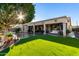 Sun-drenched backyard with covered patio, artificial turf, and mature trees at 11957 N 140Th Ln, Surprise, AZ 85379