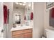 Clean bathroom with wood vanity and red towels at 11957 N 140Th Ln, Surprise, AZ 85379