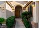 Front entry with arched doorway and lush landscaping at 11957 N 140Th Ln, Surprise, AZ 85379